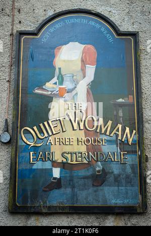 Vintage-Beschilderung an der Außenseite des „Quiet Woman“ Publishauses, Earl Sterndale, Derbyshire. Stockfoto