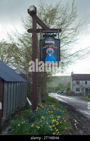 Vintage-Beschilderung an der Außenseite des „Quiet Woman“ Publishauses, Earl Sterndale, Derbyshire. Stockfoto