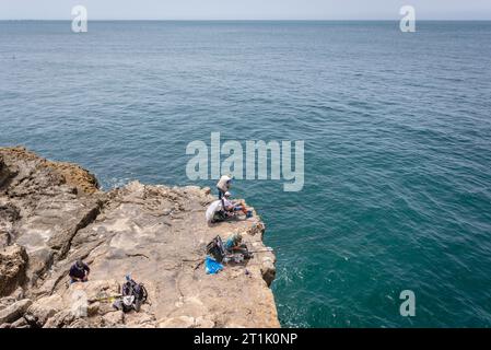 Angler über Boca do Inferno - Hells Mundschlucht in den Küstenklippen bei Cascais, im Bezirk Lissabon, Portugal Stockfoto