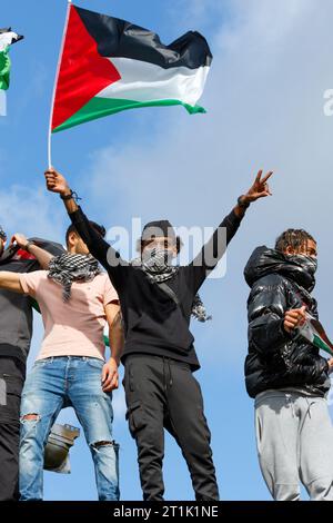 Bristol, Großbritannien. Oktober 2023. Pro-palästinensische Unterstützer, die auf dem Dach eines Bandstandes im Castle Park stehen, werden mit palästinensischen Fahnen geschwenkt, während Pro-palästinensische Unterstützer Reden vor einem propalästinensischen protestmarsch durch Bristol hören. Der protestmarsch und die Demonstration wurden abgehalten, um den Menschen zu ermöglichen, ihre Unterstützung und Solidarität mit dem palästinensischen Volk zu zeigen und gegen die jüngsten Aktionen Israels im Gaza-Streifen zu protestieren. Quelle: Lynchpics/Alamy Live News Stockfoto