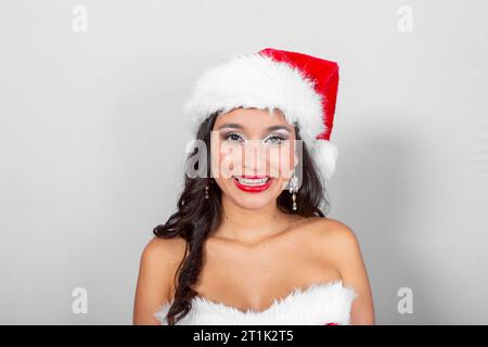 Brünette Latina-Frau, mit Hut und weihnachtsmann-Kleid in Isolation Stockfoto