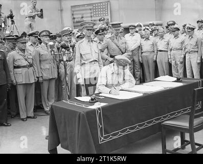 Japanisch an der Tokyo Bay, 2. September 1945 General der Armee, Douglas MacArthur Zeichen der Kapitulation als Oberbefehlshaber der Alliierten Mächte an Bord der USS Missouri ergeben. Hinter ihm stand Generalleutnant Jonathan Wainwright, die die Philippinen in die Japanische 1942 übergab, und Generalleutnant A E Percival, Singapur der Japanischen 1942 herauszugeben. Stockfoto