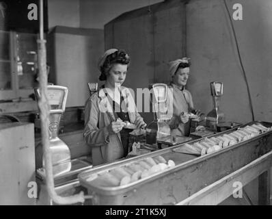 Leben an der Königlichen Marine Rüstung Depot Priddy ist hart, Gosport, 25-30 Juli 1944 Am RNAD Priddy ist hart, Gosport, Gladys Mingay, 19 Jahre, und Gladys Cox, im Alter von 39, mit einem Gewicht von RDX explosive zur Befüllung von Naval zwei Pfund Shells. Stockfoto