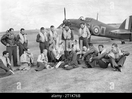 Piloten von Nr. 310 (Tschechoslowakei) Squadron RAF vor Hawker Hurricane Mk I in Duxford, Cambridgeshire, 7. September 1940. Tschechoslowakischen Piloten von Nr. 310 (Tschechoslowakei) Squadron RAF und ihre britischen Flug Kommandeure vor Hawker Hurricane Mark I, P 3143 "NN-D', in Duxford, Cambridgeshire gruppiert. Sie sind (stehend, von links nach rechts); Pilot Officer S Janduch, Sergeant J Vopalecuy, Sergeant R Puda, Sergeant K Seda, Sergeant B Furst und Sergeant R Zima: (Sitzend, von links nach rechts); Pilot Officer W Goth, Flight Lieutenant J Maly, Flight Lieutenant G L Sinclair, Flying Officer J E Boulton, Fli Stockfoto