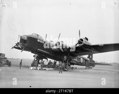 Royal Air Force 1939-1945 - Bomber Command Stirling N3663/MG-H der Nr. 7 Geschwader, auf der Heide Newmarket, Suffolk, bei einem Besuch von König Peter von Jugoslawien, 29. Juli 1941. Eine typische Bombe Last ist auf Ansicht unter dem Flugzeug für die Inspektion des Königs. Stockfoto