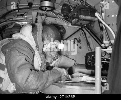 Royal Air Force Bomber Command, 1942-1945. Flying Officer P Ingleby, der Navigator eines Avro Lancaster B Mark III der Nr. 619 Squadron RAF in Coningsby, Lincolnshire, an seinem Tisch im Flugzeug sitzt. Stockfoto