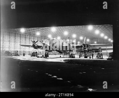 Royal Air Force Bomber Command, 1942-1945. Handley Page Halifax B Mark III Serie 1 Wie Nr. 1663 Schwere Conversion Unit Maintenance in der Nacht durchmachen in einem T 2 Typ Hangar am Rufforth, Yorkshire. Stockfoto