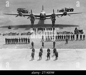 Royal Air Force Bomber Command, 1942-1945. Die Luft- und Bodencrews verantwortlich für die Wartung, Instandhaltung und fliegen von einem kurzen Stirling B Mark I der Nr. 218 Squadron RAF in Marham, Norfolk. Stehen an der Front ist der Flugbesatzungen, Kapitän, der zweite Pilot, Flugingenieur, Beobachter (Navigator), Netzbetreiber, air Gunner/Bombe aimer und zwei Air gunners. Hinter ihnen stehen die meteorologischen Offizier, ein WAAF Fallschirm Packer und der Fliegende Control Officer. Im dritten Rang stehen 12 Flug Wartung Mannschaft und 18 Boden Service Crew, und hinter ihnen die Fahrer des Traktors mit seiner Bombe - Zug in Fr Stockfoto
