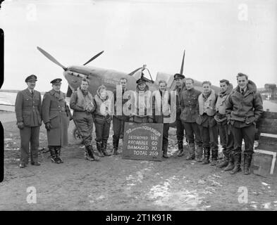 Royal Air Force Fighter Command, 1939-1945. Piloten und nicht-operative Offiziere der Nr. 92 Squadron RAF stand vor einer Supermarine Spitfire Mark I bei Manston, Kent, mit der die Staffel Scoreboard geändert Ihre 130 feindliche Flugzeuge Aufnehmen zerstört. Sie sind (von links nach rechts): Flying Officer'' Judy Garland (Engineering Officer), Flying Officer T Weiss (Intelligence Officer), Pilot Officer R Mottram, Sergeant R E'Tich'Havercroft, Flight-Lieutenant C B F Kingcombe, Squadron Leader J ein Kent (Kommandierender Offizier), Flying Officer T B A "Jock" Sherrington, Pilot Officer C H Saunders, Fliegende O Stockfoto