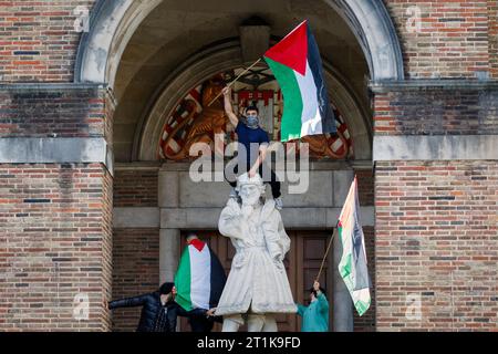 Bristol, Großbritannien. Oktober 2023. Bristol, Großbritannien. Oktober 2023. Ein pro-palästinensischer Unterstützer, der eine palästinensische Flagge schwenkt, sitzt auf der elisabethanischen Kaufmannsstatue, die vor dem Rathaus von Brisrol steht, während Pro-palästinensische Unterstützer Reden nach einem propalästinensischen protestmarsch durch Bristol hören. Der protestmarsch und die Demonstration wurden abgehalten, um den Menschen zu ermöglichen, ihre Unterstützung und Solidarität mit dem palästinensischen Volk zu zeigen und gegen die jüngsten Aktionen Israels im Gaza-Streifen zu protestieren. Quelle: Lynchpics/Alamy Live News Stockfoto