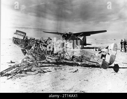 Royal Air Force Operationen im Nahen Osten und in Afrika, 1939-1943. Ein Westland Lysander Mark II Nr. 208 Squadron RAF bei El Adem Flugplatz, Libyen geparkt, kurz nach seiner Besetzung am 5. Januar 1940. Im Vordergrund sind die Überreste eines der 87 italienischen Flugzeugen zerstört auf dem Flugfeld gefunden. Stockfoto