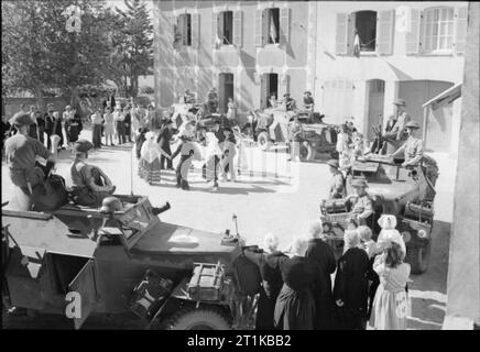 Royal Air Force - 2nd Tactical Air Force, 1943-1945. Männer von Nr. 2798 Panzerwagen Squadron RAF Regiment sehen Sie eine Anzeige der bretonischen Volkstänzen aus ihren Humber licht Aufklärung Autos in Cannes, westlich von Morlaix in Bretagne, Frankreich. Dies war das erste Mal seit 1944, dass die Dorfbewohner es erlaubt, ihre Tracht zu tragen und jede Art von öffentlichen Versammlung zu halten. Stockfoto