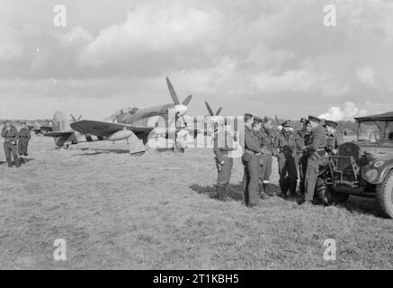 Royal Air Force - 2nd Tactical Air Force, 1943-1945. Der kommandierende Offizier der Nr. 486 Squadron RNZAF verleiht mit seinen einige seiner Piloten vor ihren Hawker Tempest Mark Vs bei B60/Grimbergen, Belgien. Die Gruppe besteht aus, (von links nach rechts); Flying Officer N J Powell, Pilot Officer W A L Trott, Flying Officer R J Cammock, Warrant Officer A H Bailey, Pilot Officer S J Kurz, Flying Officer J H Stafford, Flight Lieutenant H M Sweetman, Squadron Leader J H Iremonger (CO) und Flight Lieutenant E W Tanner. Stockfoto