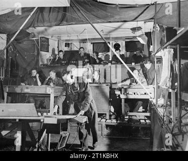 Royal Air Force - 2nd Tactical Air Force, 1943-1945. RAF und Armee bei der Arbeit in der Operations Zimmer an Nr. 483 Group Control Center in der Normandie. 483 GCC ausgeübt Gesamtleitung und Steuerung von Flugzeugen innerhalb Nr. 83 Bereich der Tätigkeit des Konzerns, und befasste sich mit Anfragen für die Unterstützung von Armee Formationen. Stockfoto