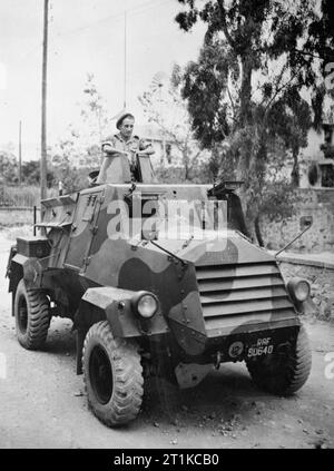 Royal Air Force - Italien, auf dem Balkan und in Südosteuropa, 1942-1945. Sergeant G H Wingate von Nr. 2908 Feld Squadron RAF Regiment in den Revolver eines Otter licht Aufklärung Auto in Athen sitzen, nachdem das Militär Medaille für seine Handlungen während einer Auseinandersetzung mit den deutschen Truppen im Norden Griechenlands ausgezeichnet. Am 28. Oktober 1944, 2908 Staffel verfolgten Deutschen an der jugoslawischen Grenze zurückziehen. Ein Panzerwagen angetrieben von Sergeant (dann Corporal) Wingate war reine Markterkundungs feindliche Stellungen bei Kozani, wenn es unter Feuer von einem 37 mm Anti-tank Gun kam und erhielt mehrere direkte Treffer, nicht Stockfoto