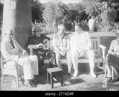 Winston Churchill während des Zweiten Weltkriegs im Nahen Osten Winston Churchill sitzt auf einer Bank im Garten der Britischen Botschaft in Kairo mit dem britischen Botschafter Sir Miles Lampson und andere im August 1942 begleitet. Stockfoto