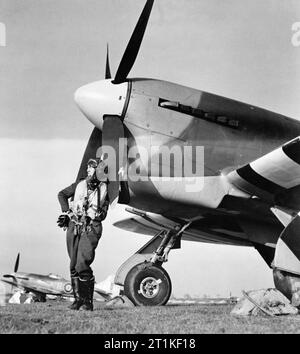 Flying Officer J R Cullen von Nr. 486 Squadron RNZAF, vor seinem Hawker Tempest Mk V bei Castle Camps, Cambridgeshire, 8. April 1944 Stellung. Flying Officer J R Cullen von Nr. 486 Squadron RNZAF, vor seinem Hawker Tempest Mark V auf Schloss Camps, Cambridgeshire. Cullen wurde ein erfolgreicher Betrieb DIVER Pilot mit dem Geschwader,, Abschuss rund 16 fliegende Bomben gegen das Vereinigte Königreich eingeleitet. Zwischen Februar und Oktober 1945 befahl er Nr. 183 Squadron RAF, fliegende Strassenverkäufer Taifune. Stockfoto