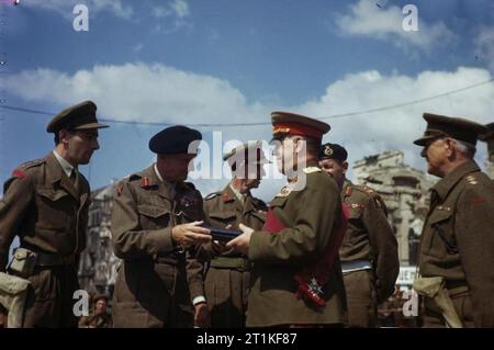 Feldmarschall Montgomery schmückt russischen Generäle am Brandenburger Tor in Berlin, Deutschland, 12. Juli 1945 stellvertretender Oberster Befehlshaber der Roten Armee, Marschall G Schukow wird als Knight Grand Cross des Ordens der Badewanne vom Kommandeur des 21. Armee, Feldmarschall Sir Bernard Montgomery, von britischen Offizieren beobachtete investiert. Zweite von rechts ist Major General L O Lyne, Kommandant der 7. Gepanzerten Division. Die Zeremonie fand am Brandenburger Tor in Berlin und ein Spalier wurde von der 7. Gepanzerten Division gebildet. Stockfoto