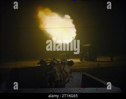 Die Auxiliary Territorial Service zu einem Anti-Aircraft Gun Site in Großbritannien, Dezember 1942 eine Batterie von 4,5 Zoll Flugabwehrkanonen in Aktion in der Nacht. Im Vordergrund ist eine ATS-Abschnitt die Höhe Finder. Stockfoto