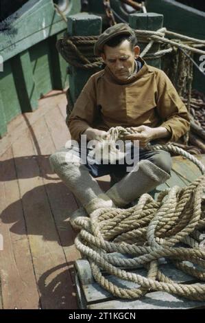 Der Heimatfront in Großbritannien 1939-1945 Der Krieg: Herr De Groote, einer belgischen Fischer spleißen Seil auf dem Deck eines Fischerboot in Brixham, Devon. Stockfoto