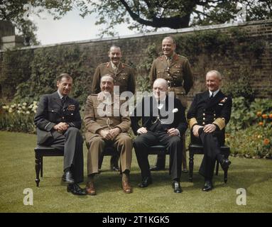 Der Ministerpräsident, die Rt Hon Winston Churchill, mit seinen Stabschefs im Garten Nr. 10 Downing Street, London, 7. Mai 1945 Sitzend, von links nach rechts: Air Chief Marshal Sir Charles Portal; Feldmarschall Sir Alan Brooke, die Rt Hon Winston Churchill; Admiral Sir Andrew Cunningham. Stehend von links nach rechts: die Sekretärin des Chefs der Mitarbeiter des Ausschusses, Major General L C Hollis; und Stabschef an den Verteidigungsminister, General Sir Hastings Ismay. Stockfoto