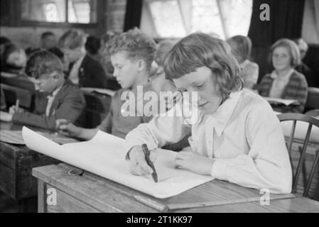 Ein Dorf speichert - die nationalen Ersparnisse in Lewknor, Oxfordshire, England, 1941 Joan Hartwell, Schüler an der Dorfschule in Lewknor, konzentriert sich auf das Plakat ist sie Zeichnen als Teil einer Konkurrenz durch die nationalen Ersparnisse Ausschuss organisiert. Das beste von diesen Plakaten nach London geschickt werden im Rahmen des Wettbewerbs beurteilt werden.. Stockfoto