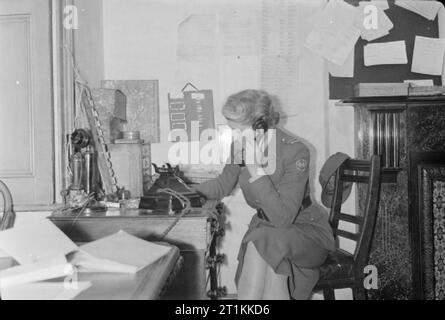 Fliegende Bombe - V1 Bombenschäden in London, England, UK, 1944 eine Frau der amerikanischen Krankenwagen Großbritannien erhält einen Anruf ihre Teilnahme beantragen bei einem Vorfall. Stockfoto