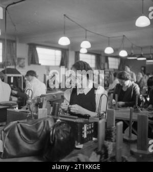 Von Sesseln zu Bomber - Krieg in Cleveland Möbel Showroom, Kingston, Surrey, 1943 Anker Spulen sind "getestet" durch Teil-Frauen Zeit Krieg Arbeiter, die in einer "Fabrik" in der teilweise umgebauten Cleveland Möbel Showroom in Kingston. Das Unternehmen produziert jetzt elektrische Ausrüstung für die Royal Air Force Bomber. Stockfoto