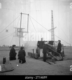 Mädchen Gunners - die Arbeit der Auxiliary Territorial Service auf eine experimentelle Station, Shoeburyness, Essex, England, 1943 Frauen der ATS wie ein 25 pfünder Shell an der Königlichen Artillerie experimentelle Station bei Shoeburyness gezündet wird. Die shell wird durch eine Geschwindigkeit angezeigt, der die Drehzahl der shell Maßnahme wird gefeuert. Die Schalen sind in das Meer bei Ebbe gefeuert. Stockfoto