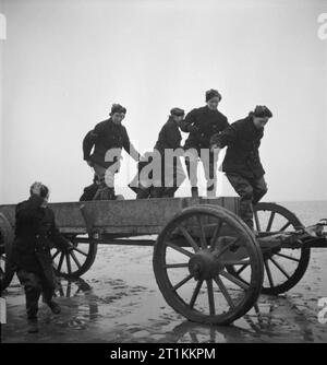 Mädchen Gunners - die Arbeit der Auxiliary Territorial Service auf eine experimentelle Station, Shoeburyness, Essex, England, 1943 Frauen der ATS nach unten springen aus dem Pferdewagen, die Sie auf den Sand bei Shoeburyness durchgeführt hat, bei Ebbe. Ihre Aufgabe ist es, bis zum Muscheln sammeln, die ins Meer bei Flut von der Königlichen Artillerie abgefeuert worden war. Jede shell ist markiert, so dass Tests und Überprüfungen möglich sind. Stockfoto