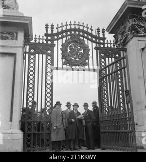 Harry Hargreaves geht es zum Buckingham Palace - von Yorkshire nach London zu sammeln seine Britische Empire Medal, 1943 Harry Hargreaves vor den Toren des Buckingham Palace kommt, umklammerte seinen Brief der Anweisung. Er wird von anderen Medaillengewinner, die bald das Palace geben Sie ihre Ehren zu sammeln umgeben. Stockfoto