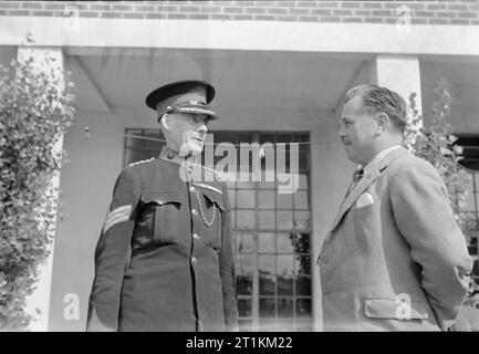 Holiday Camp wieder gehen - den Alltag bei einem Butlins Holiday Camp, Filey, Yorkshire, England, UK, 1945 Billy Butlin, MBE, (rechts) Chats zu Sergeant J Caffrey, VC, (links) eine der Commissionaires bei Filey Holiday Camp. Gemäß der ursprünglichen Caption, Sgt Caffrey, VC, gewann seine Victoria Cross bei Ypern während des Ersten Weltkrieges. Stockfoto