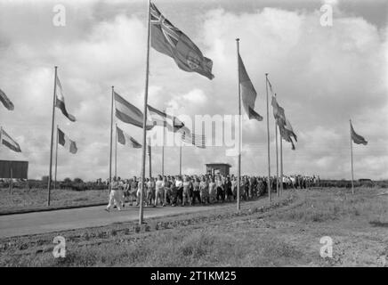 Holiday Camp wieder gehen - den Alltag bei einem Butlins Holiday Camp, Filey, Yorkshire, England, UK, 1945 geführt von einer der Physischen Ausbildung Ausbilder, Wohnmobile an Butlin's Holiday Camp, Filey, März durch die Flagge gesäumten Eingang in das Lager bei einer der täglich am frühen Morgen PT-Sitzungen, die das Camp. Stockfoto