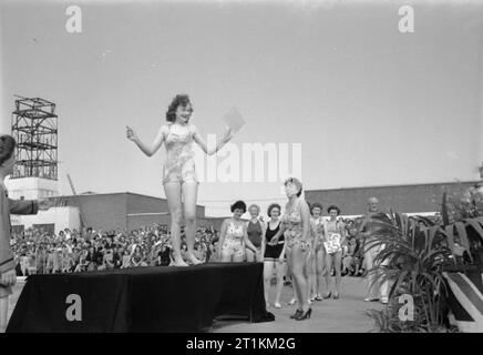 Holiday Camp wieder gehen - den Alltag bei einem Butlins Holiday Camp, Filey, Yorkshire, England, UK, 1945 Frauen im Rahmen der "Holiday Lovelies" Parade in der Sonne nehmen neben dem Pool an Butlin's Holiday Camp, Filey. Eine Frau in einer Zeit nimmt, um zu einem Sockel aus zu Ihrem 'Lieblichkeit" zeigen. Die Parade wird von ex-ATS instructress Billie Brunnen (rechts), die jetzt auf dem Camp Arbeiten geführt. Gemäß der ursprünglichen Caption, 'Lovelies Parade zieht die größte Masse der überfüllten Butlin Woche zum Camp Pool'. Stockfoto