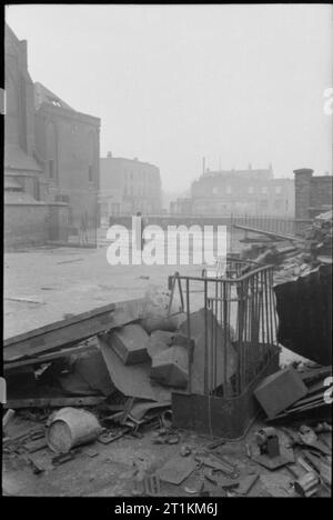 Die Kirche erhebt sich aus der Asche - Bombenschäden zur St. George's Cathedral, Southwark, 1942 Vater Dixon steht auf dem Gelände der einst die Schule St. George's Römisch-katholische Kathedrale befestigt, an der Ecke von St. George's Road und Lambeth Road, Southwark. Die Kathedrale wurde streng nach einer Brandbombe Angriff am 16. April 1941 beschädigt. Schutt und Trümmern und alte Geländer, können im Vordergrund gesehen werden. Stockfoto