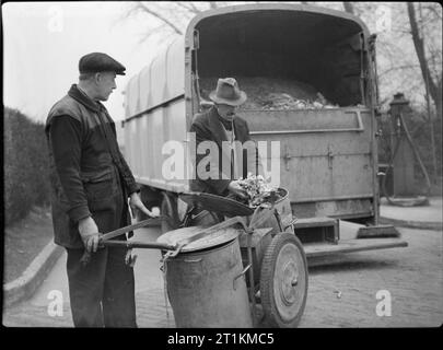 Küchenabfällen in Futtermitteln für Rinder - Bergung auf dem britischen Home Front, 1942 Bergung Arbeitnehmer durch die Haushalte Botschaften, die sie in ihren Müll Trolley, bevor Sie sie auf dem großen Staub Warenkorb hinter ihnen gesammelt haben. Stockfoto