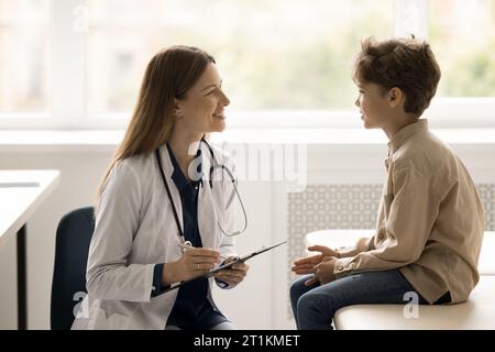 Junge Kinderärztin spricht mit kleiner Patientin Stockfoto