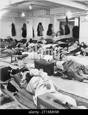 Leben in einem Keller Luftschutzbunker, London, England, 1940 Schlafen shelterers Linie der Boden in den Keller eines Kaufhauses, möglicherweise Dickins und Jones, im Londoner West End im November 1940. Männer und Frauen liegen auf dünnen Matratzen und Decken. Viele haben Koffer mit Ihnen und Mäntel und Hüte haben auf die Nägel an den Wänden. Stockfoto