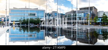 CENTENARY SQUARE, BIRMINGHAM, GROSSBRITANNIEN - 5. OKTOBER 2023. Panoramablick auf Birmingham's neue Symphony Hall und das Rep Theater spiegeln sich im Wasser Stockfoto