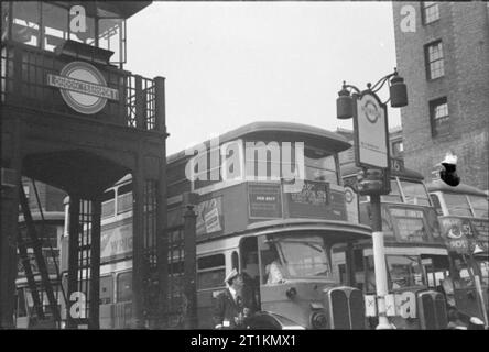Die Londoner Busse in Kriegszeiten, England, 1941 mehrere London Transport Busse bis an ihren Stationen gesäumt sind, bereit, den Fluggästen zu erhalten. Neben den Haltestellen kann der Eingang zu einer Londoner U-Bahn gesehen werden, die zum Bahnhof Victoria "Tube". Dieses Foto wurde wahrscheinlich im September 1941 übernommen. Stockfoto