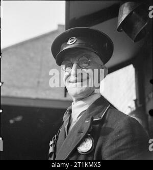 Die Londoner Busse in Kriegszeiten, England, 1941 London Bus Dirigenten George Burrell Lächeln für die Kamera am Busbahnhof, wahrscheinlich an der Victoria, London. Dieses Foto wurde wahrscheinlich im September 1941 übernommen. Stockfoto