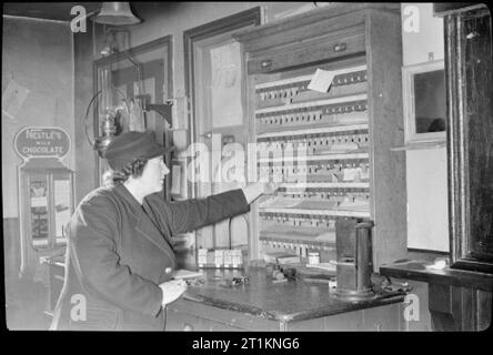 Naher Osten Sergeanten Frau Einweisende's Job-Leben Als Eisenbahn Signalwoman, Molland, Devon, England, UK, 1943, als auf die Frühschicht (von 5:15 Uhr bis 1:20 Uhr), Signalwoman Daisy Kochen hilft Problem Tickets bei der Buchung Büro im Molland station. Stockfoto