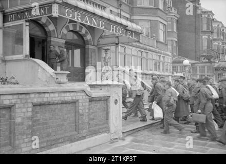 Neuseeland Aussiedler in England ankommen - den Alltag für die Heimschaffung der Kriegsgefangenen in Ramsgate, Kent, England, UK, April 1945 eine große Gruppe von Neuseeland ex-Kriegsgefangenen Erklimmen der Treppe zum Haupteingang des Grand Hotel, Westcliff, Margate, die als Reception Center verwendet wird. Sie sind alle mit KITBAGS oder Rucksäcke. Stockfoto