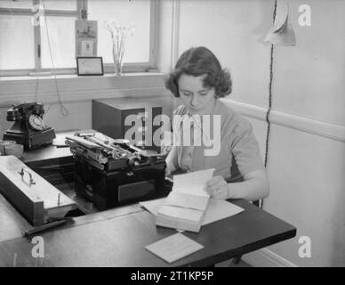 Nacht School Girl - Abendkurse in Kriegszeiten London, C 1940 Frau Ridley arbeitet an ihrem Schreibtisch im Institut für Arbeitsmarkt, wo sie als Stenotypistin. Frau Ridley's Ehemann ist in der Royal Air Force in Frankreich. Stockfoto