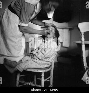 Kindergarten - Leben im alten Herrenhaus, Wendover, Buckinghamshire, England, 1944 ein junges Kind hat ihre Zähne für Ihr von einer der Krankenschwestern an das alte Herrenhaus, Wendover gereinigt. Stockfoto