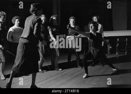 Königliche Akademie der Musik - die Arbeit der Königlichen Akademie in Kriegszeiten, London, England, UK, 1944 an der Königlichen Akademie für Musik, Mademoiselle Helene Bertrand (links) führt eine Lektion im Fechten. Gemäß der ursprünglichen Bildunterschrift, dies ist ein wesentlicher Teil des Kurses in Sprache und Drama, [wie es] gibt Studenten Poise". Die ursprüngliche Beschriftung besagt auch, dass Mlle. Bertrand ist die Tochter eines berühmten fechten Ausbilder. Stockfoto