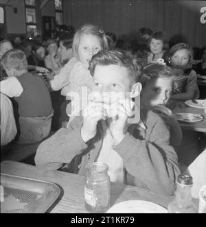 Schule für Umsiedler - Alltag an der Marchant Hill Camp Schule, Hindhead, Surrey, England, UK, 1944 Reg Phillips (Alter 13) aus East Ham für den Transport in eine große Scheibe Brot und Marmelade im Speisesaal auf der Marchant Hill School, Hindhead. Gemäß der ursprünglichen Bildunterschrift, Reg's Vater ist in der Handelsmarine. Stockfoto