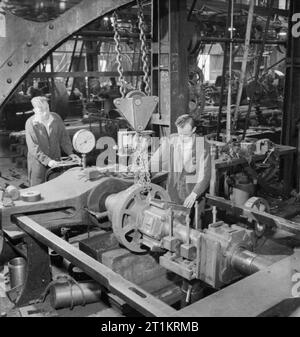 Die britische Lokomotive Gebäude Industrie - die Herstellung von Lokomotiven, UK, 1945 In der motion Shop einer großen Lokomotive arbeitet, irgendwo in Großbritannien, Arbeiter drücken Sie das drehgestell Räder eines Südafrikanischen Eisenbahnen 15 F Typ Lok auf der Achse. Gemäß der ursprünglichen CAPTION,'das Rollenlager Achse Box ist bereits an der richtigen Stelle". Stockfoto