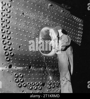 Die britische Lokomotive Gebäude Industrie - die Herstellung von Lokomotiven, Großbritannien, 1945 ein Handwerker schweißt die firehole Platten von einem Südafrikanischen Eisenbahnen 15 F Typ Lok, an einer großen Lokomotive arbeitet irgendwo in Großbritannien. Nach dem ursprünglichen Titel' elektrische Schweißarbeiten erweist sich als zufriedenstellend in vielen Anwendungen die Lokomotive Industrie. Fertigung durch Schweißen von Stahl innere fireboxes hat Praxis geworden, wie das Schweißen von den äußeren und inneren firebox Platten hat zu jedem anderen'. Stockfoto