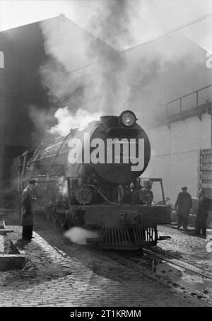 Die britische Lokomotive Gebäude Industrie - die Herstellung von Lokomotiven, Großbritannien, 1945 ein eindrucksvolles Foto eines abgeschlossenen Südafrikanischen Eisenbahnen 15F Klasse Lokomotive, ein Dampfbad in einem großen Locomotive Works getestet, irgendwo in Großbritannien. Der Motor hat alle Zylinder Gelenke unter vollen Kesseldruck getestet. Stockfoto